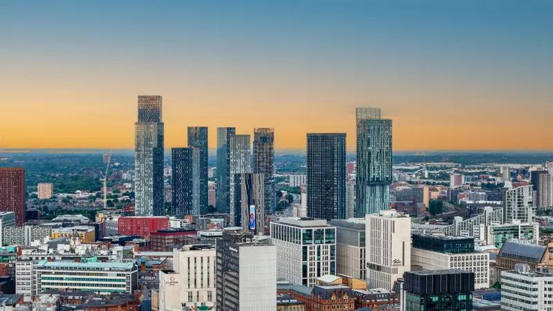 Manchester city centre skyline at dawn, seen from a rooftop