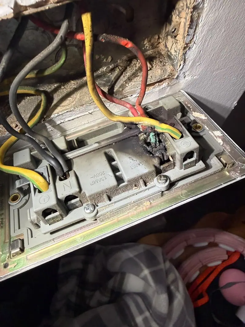 Scorched socket terminal, the kind of defect coded C1 or C2 on an EICR